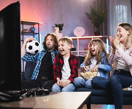 family watching a soccer game on the couch