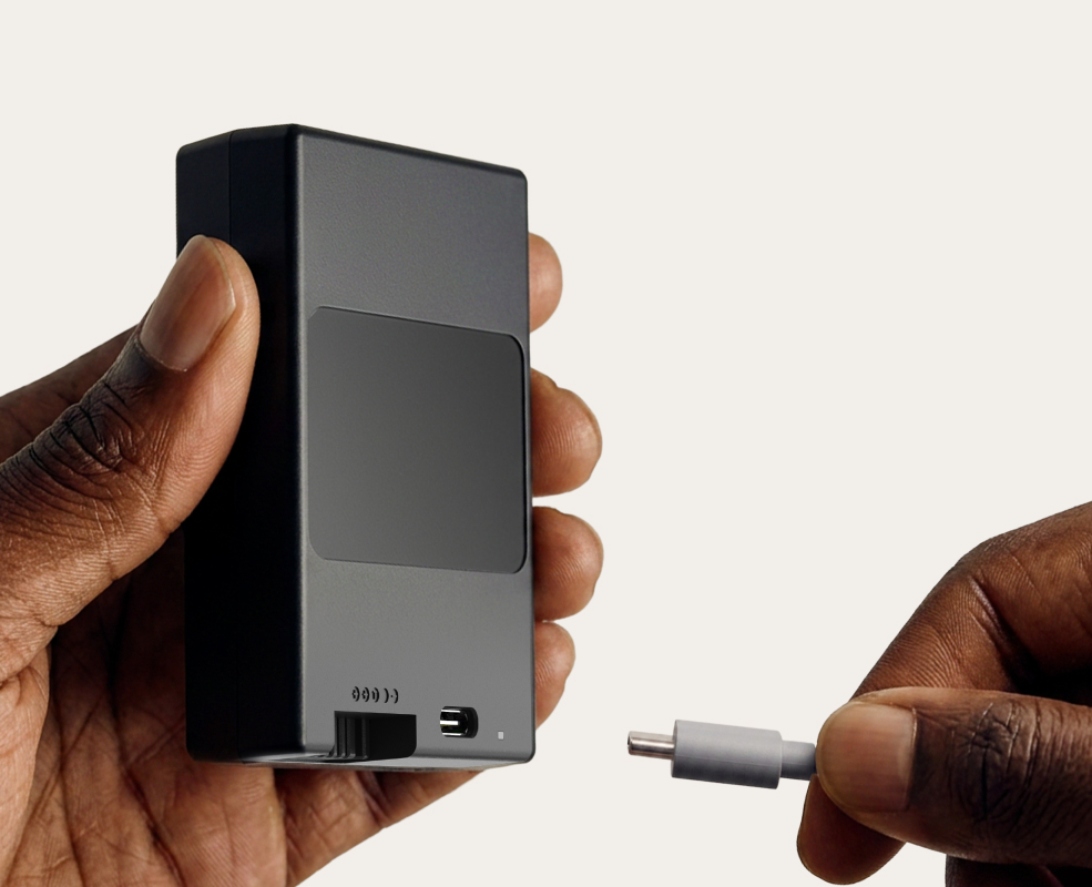 hands plugging a charger into the battery