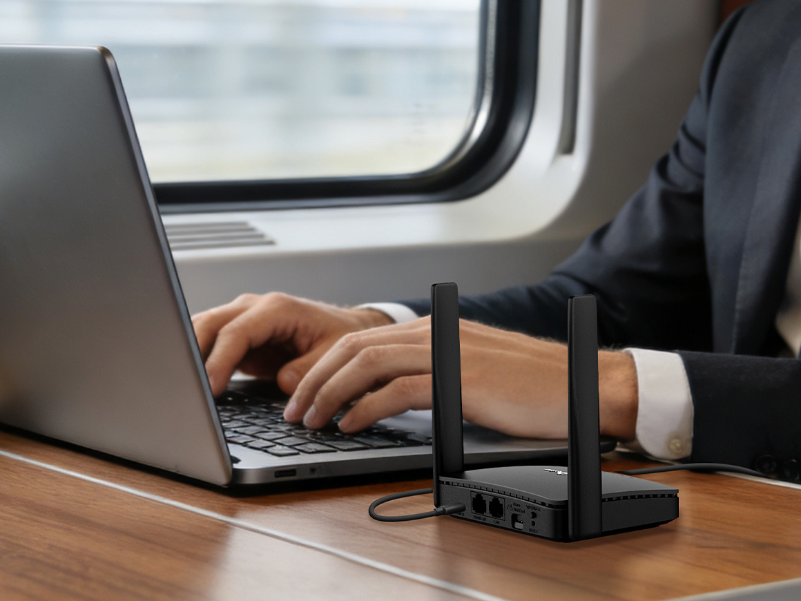 Man using a laptop and router in a train